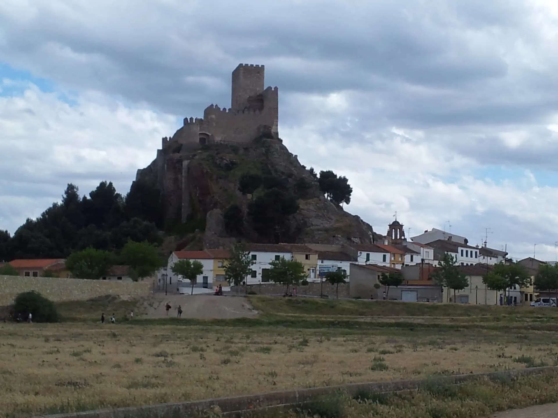 Castillo de Almansa sobre un peñasco rocoso, con casas blancas a sus pies