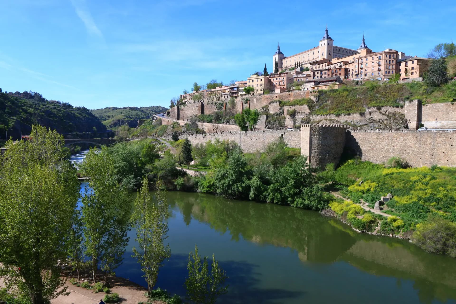 El Alcázar de Toledo y la muralla sobre el río Tajo en un día despejado de primavera