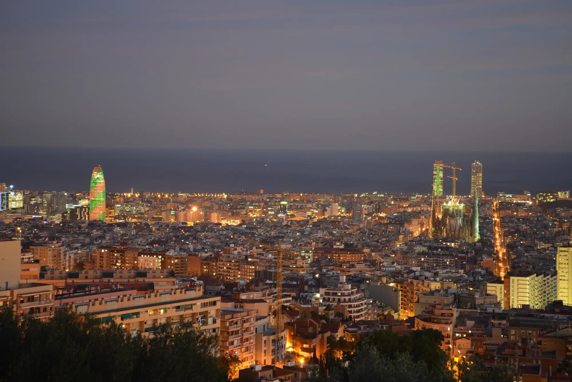 Vista de Barcelona al anochecer desde el Carmel, con la Torre Glòries y la Sagrada Família frente al mar