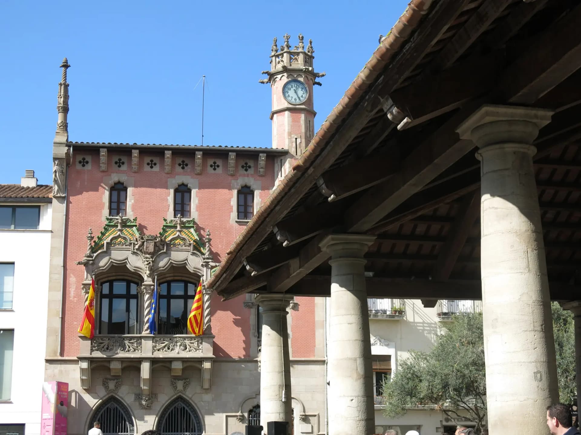 Columnas y tejado de la Porxada de Granollers con el edificio modernista del Ayuntamiento al fondo