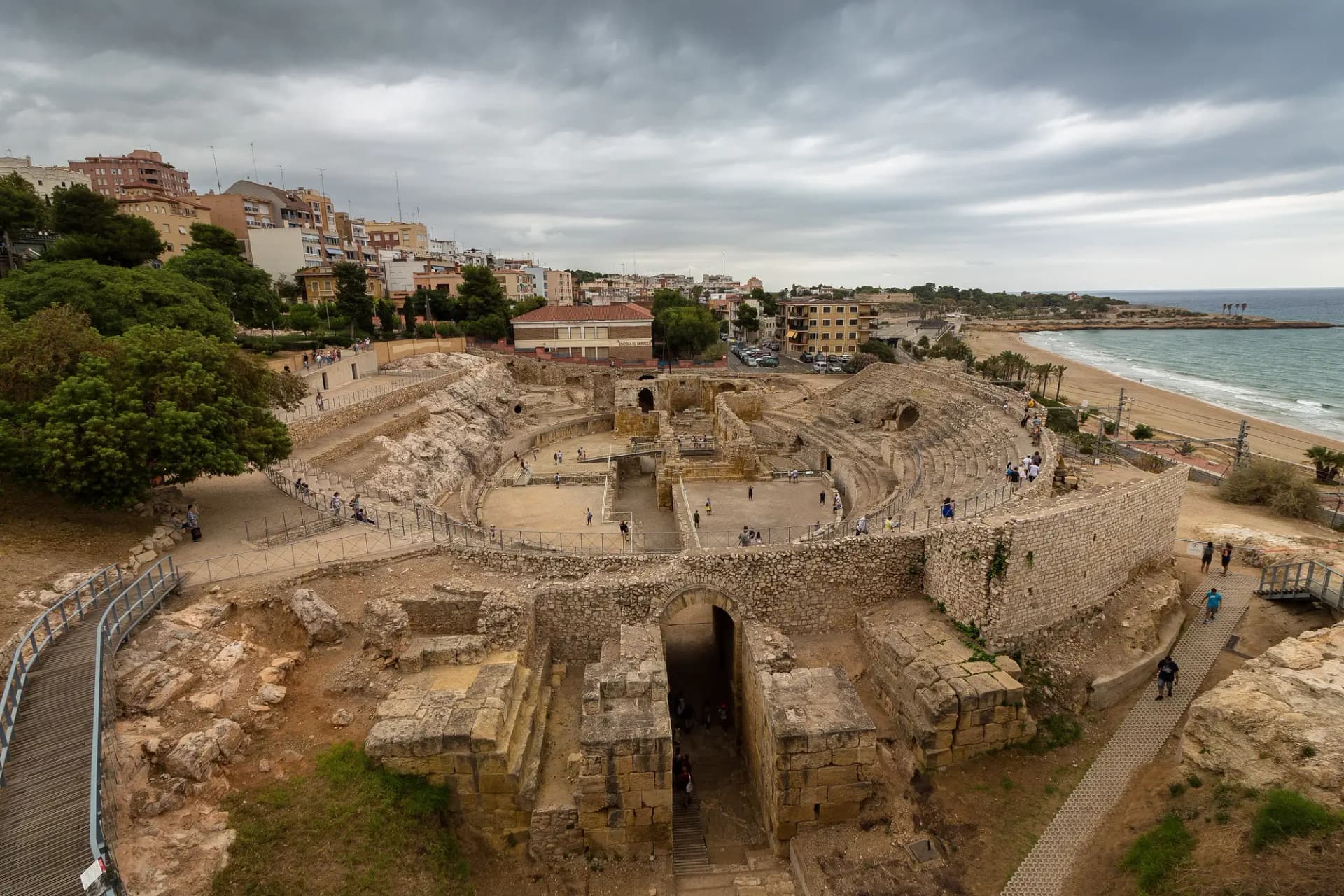 El anfiteatro romano de Tarragona junto a la playa, con la ciudad detrás
