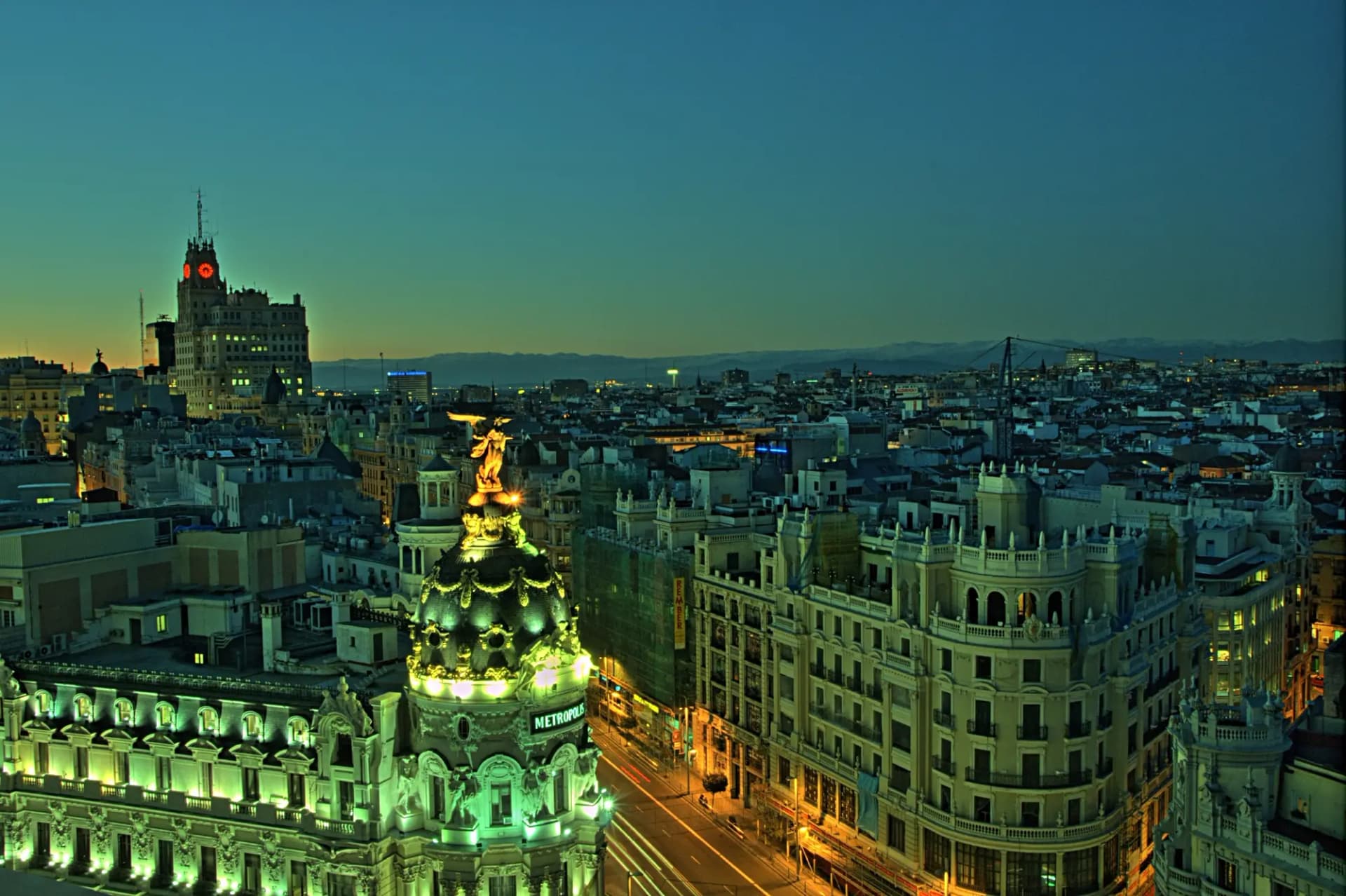 El edificio Metrópolis y el arranque de la Gran Vía de Madrid al anochecer, vistos desde una azotea
