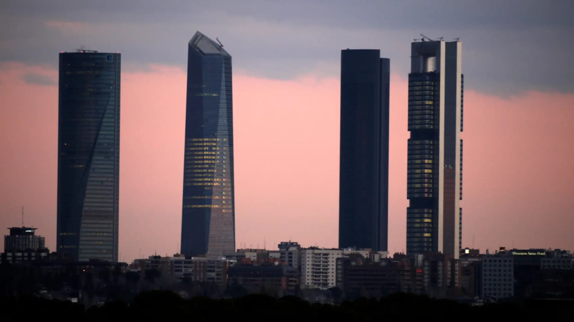 Los cuatro rascacielos de la Cuatro Torres Business Area recortados sobre el cielo rosado del atardecer