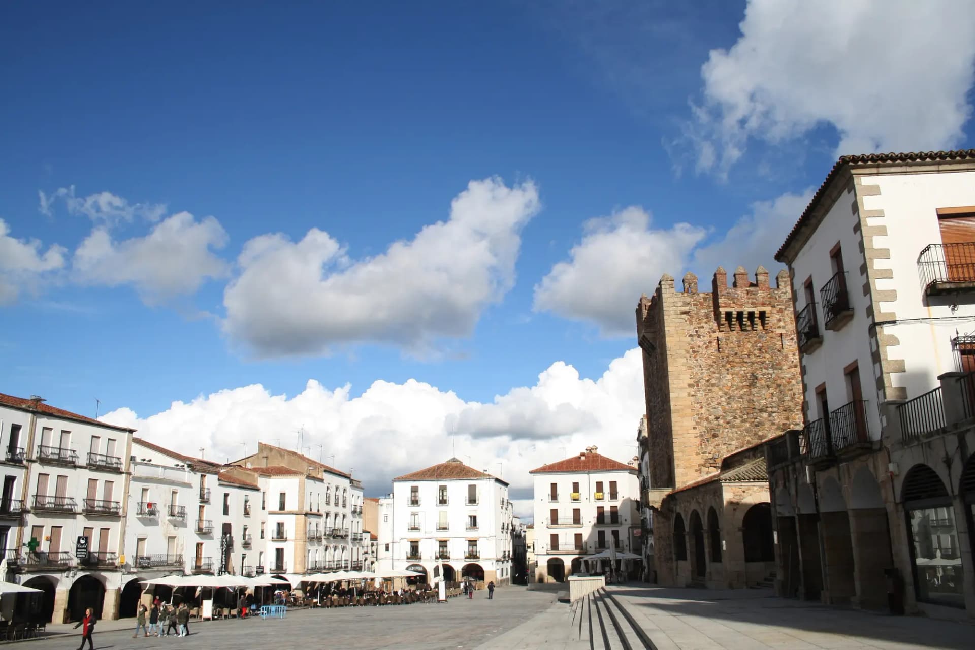 La plaza Mayor de Cáceres con la torre de Bujaco a la derecha y casas blancas con soportales