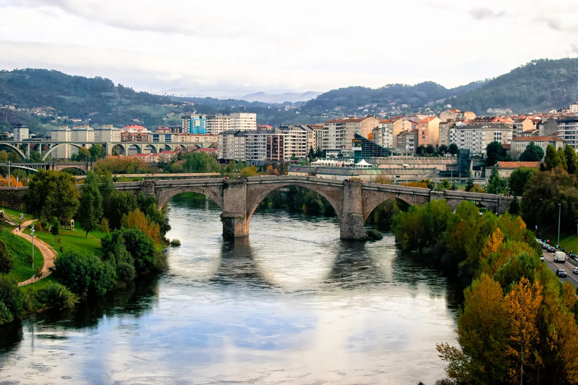 Puente romano de Ourense sobre el río Miño, con la ciudad y los montes al fondo