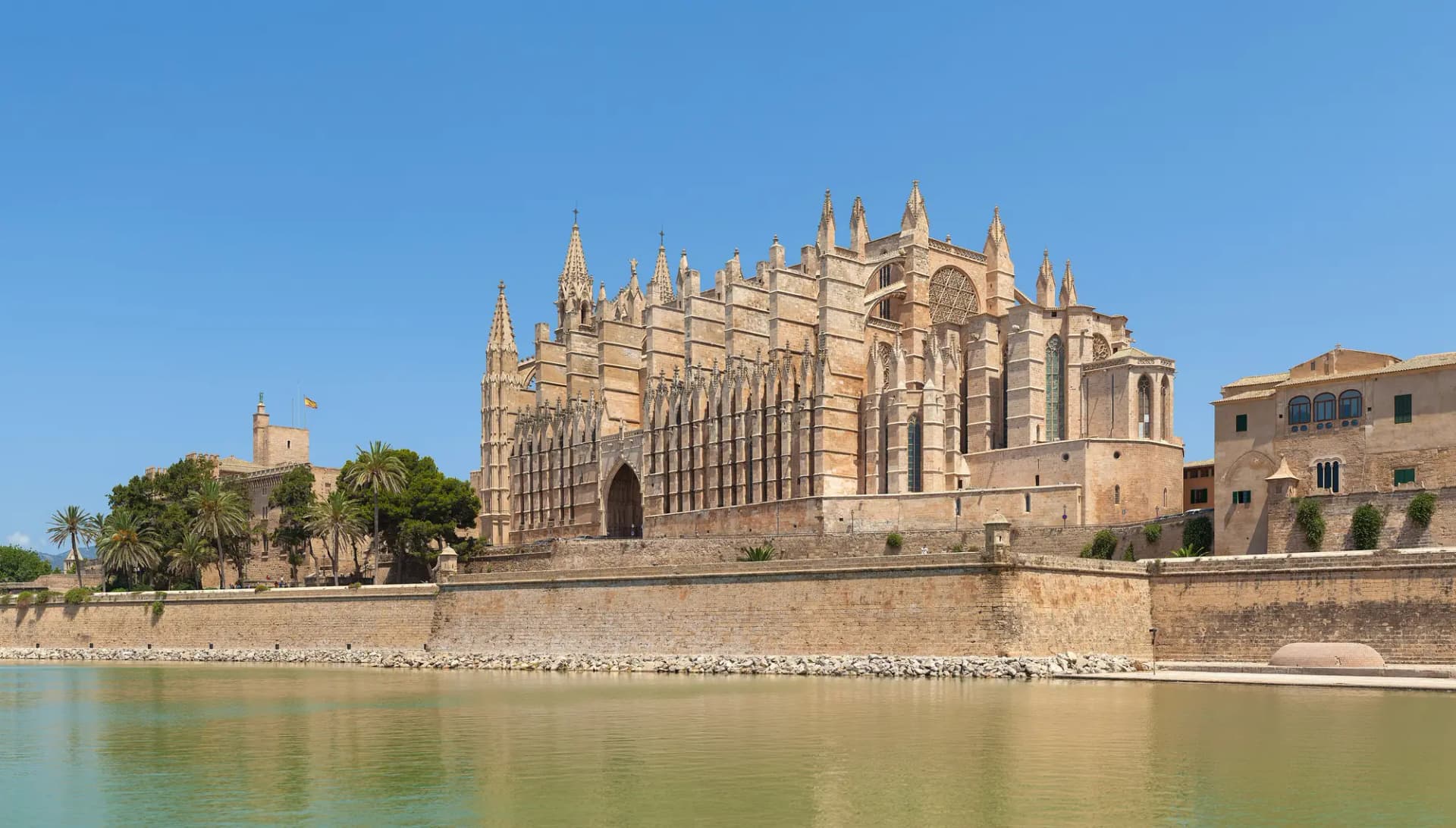 La catedral de Palma sobre la muralla, reflejada en el lago del parque del Mar