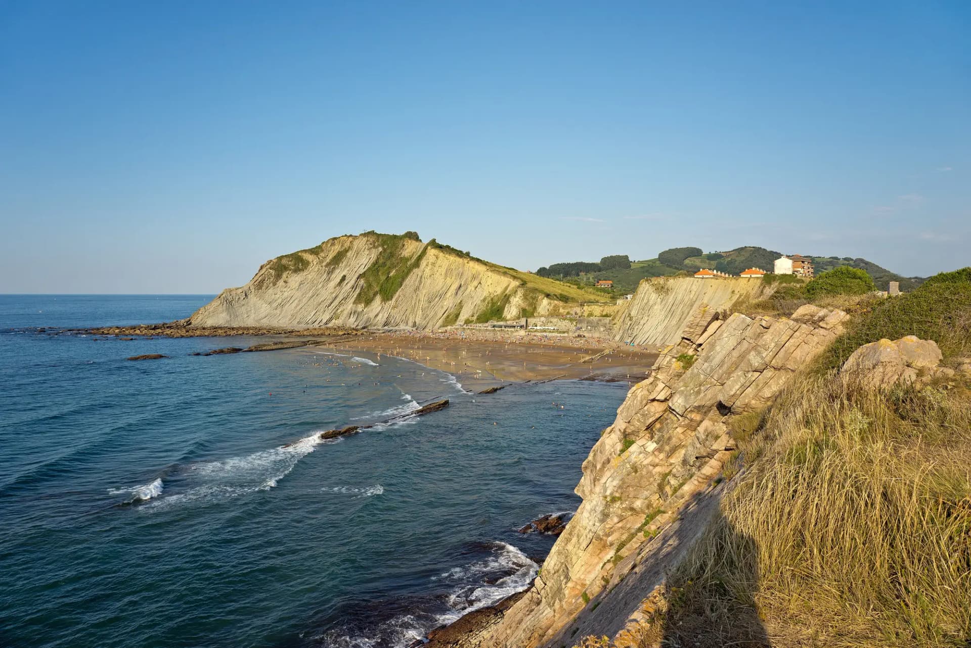 Acantilados de flysch y playa de Itzurun en Zumaia, con el mar Cantábrico a la izquierda