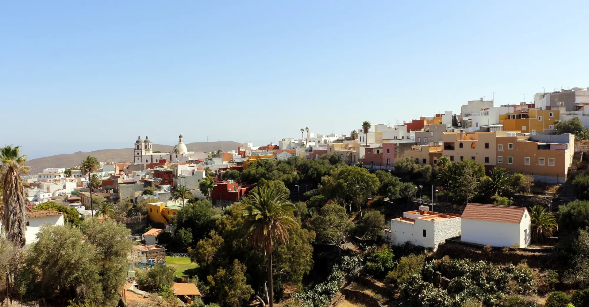 Vista de Ingenio con casas de colores entre palmeras y las torres de la iglesia de la Candelaria