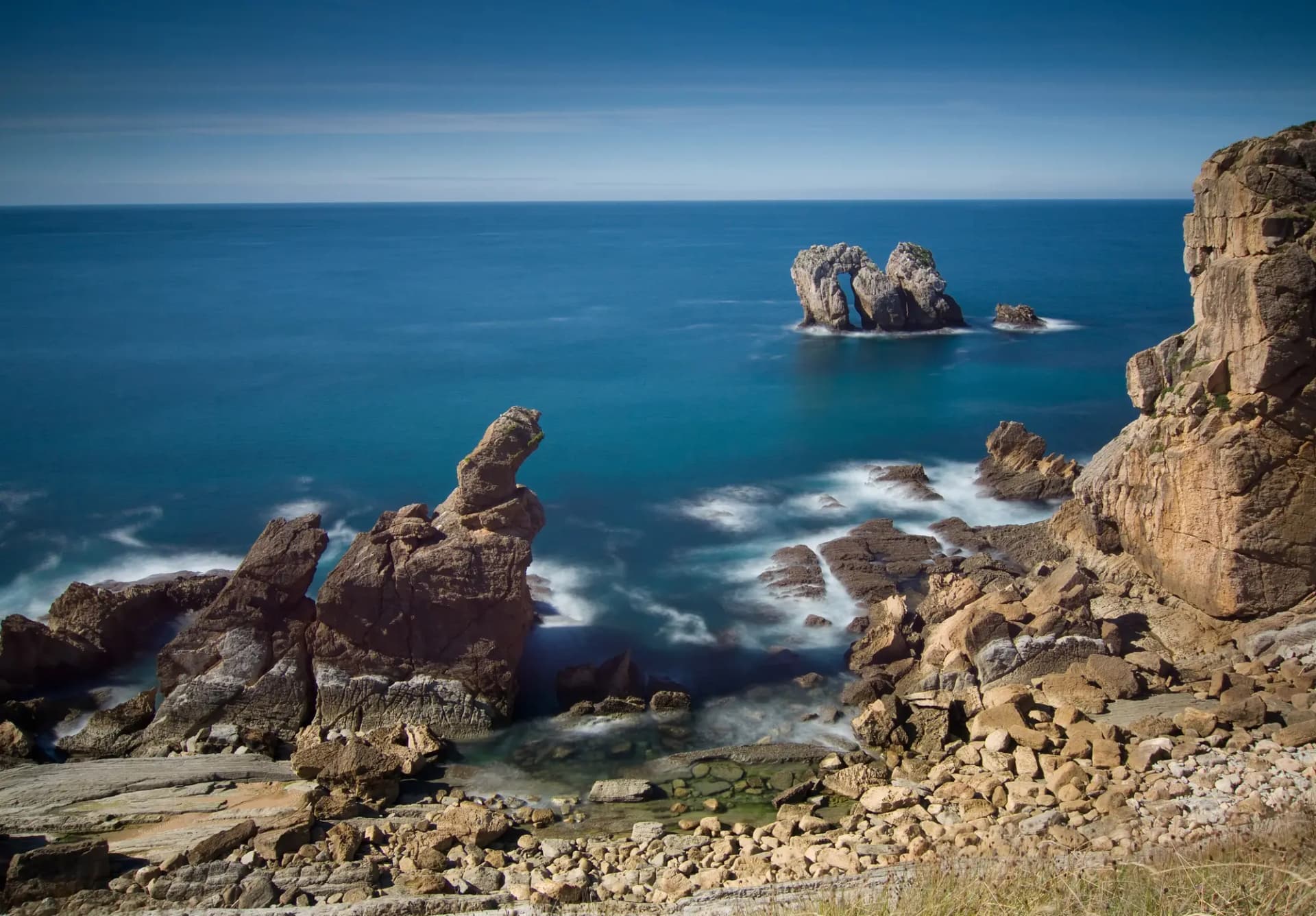 Los Urros, islotes de roca frente a la costa de Liencres, con el mar Cantábrico de fondo