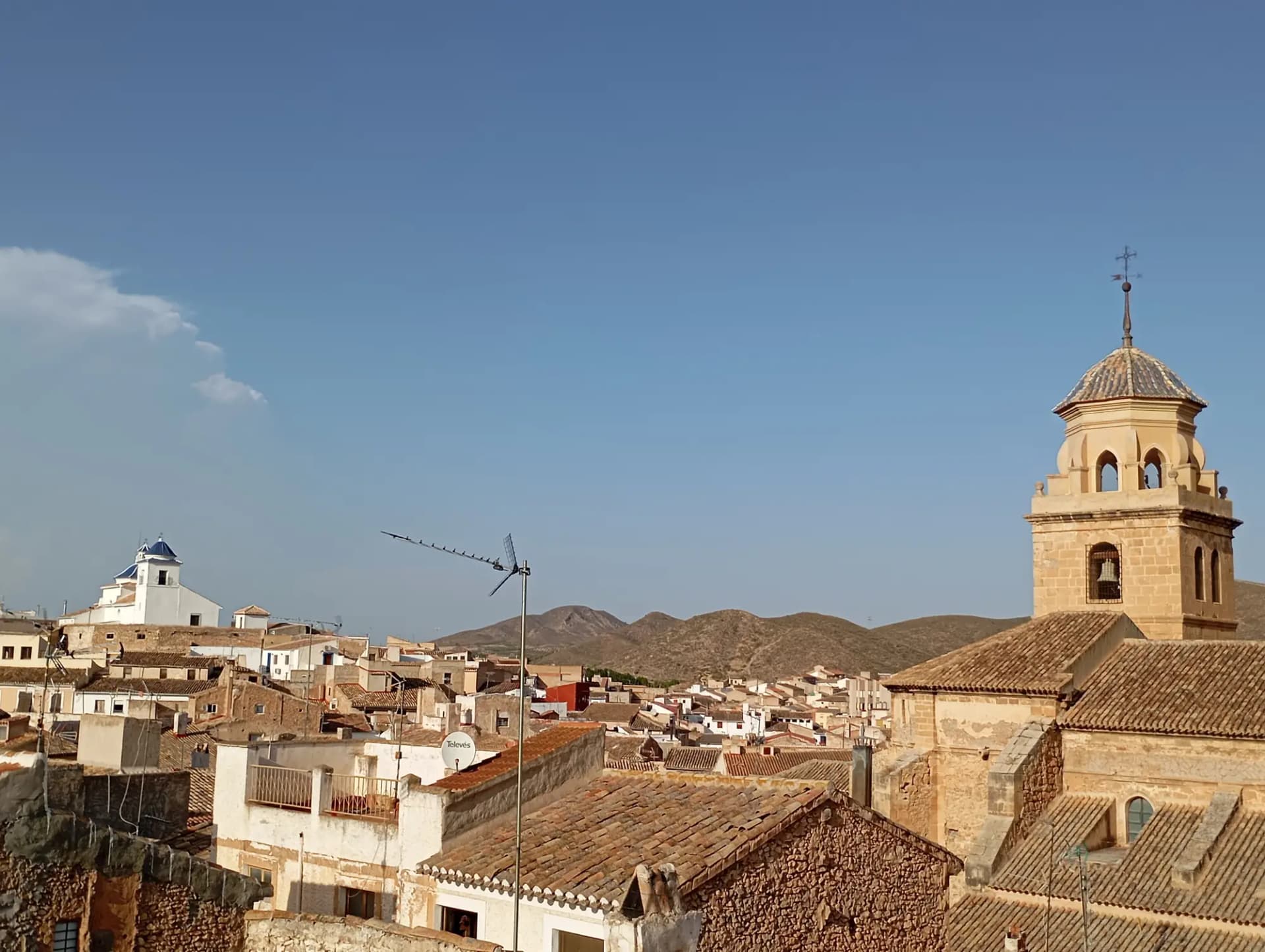 Tejados del casco antiguo de Hellín con la torre de una iglesia y los cerros al fondo
