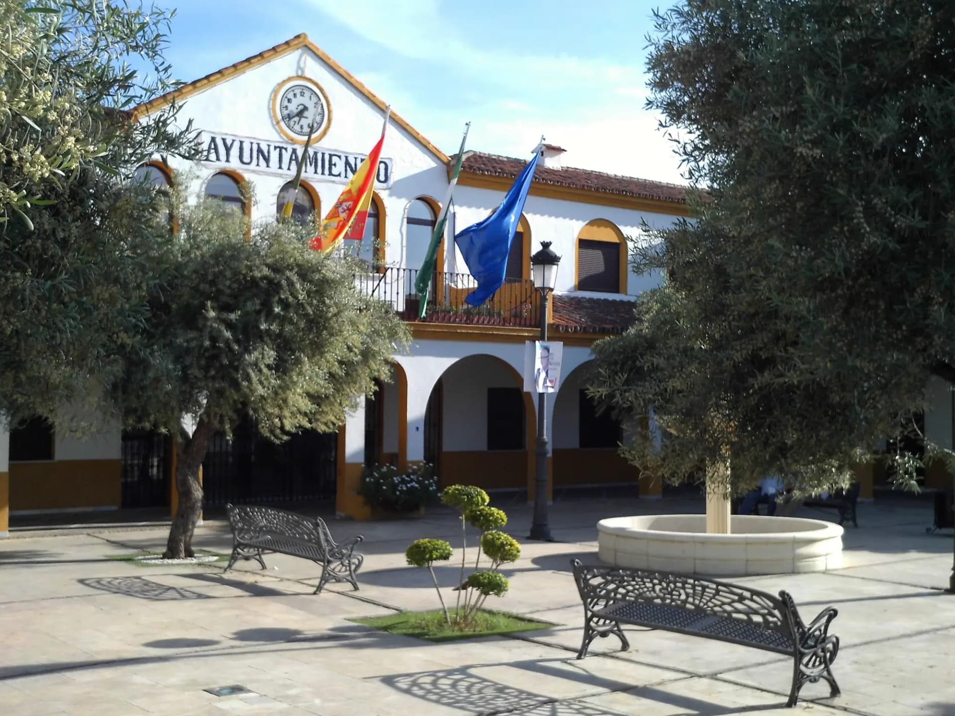 Plaza de Andalucía de Bormujos con el edificio del Ayuntamiento, olivos y una fuente