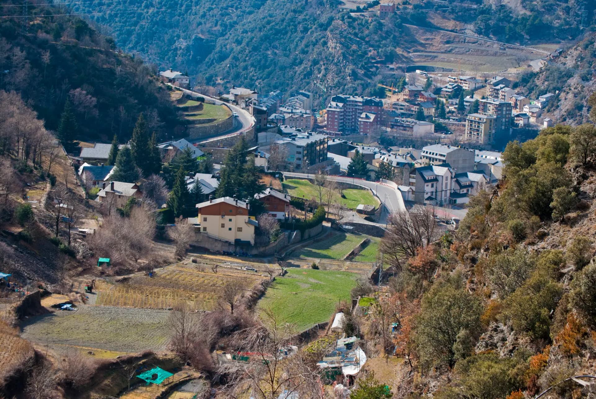 Vista de Sant Julià de Lòria desde la ladera, con huertos en primer plano y los edificios de la vila en el fondo del valle