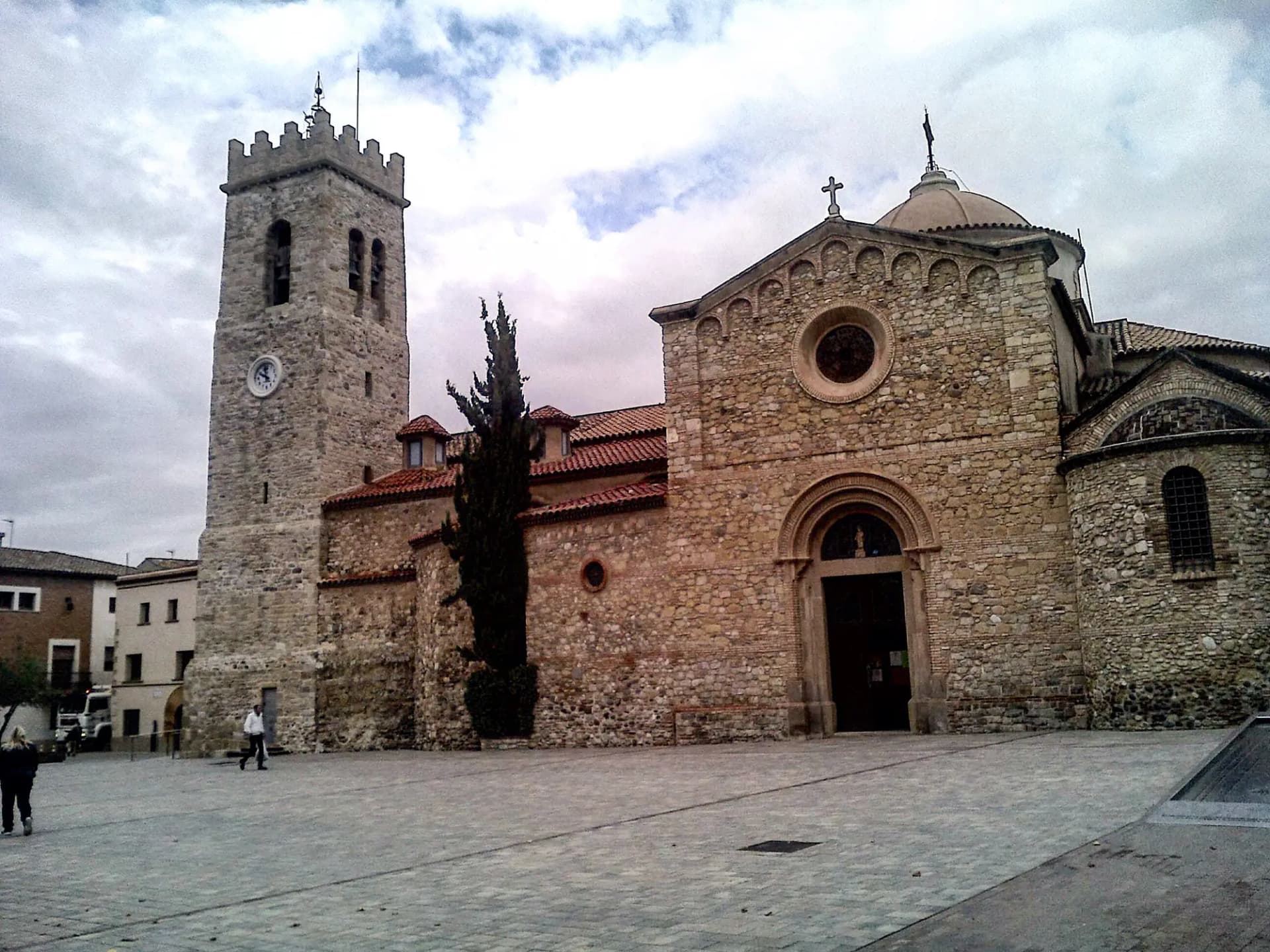 Iglesia de Sant Pere de Rubí, de piedra, con su campanario y la plaza adoquinada delante